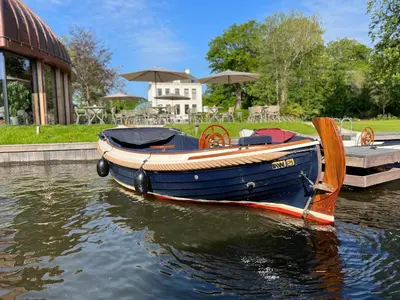 a small blue boat sitting in the water at Hotel Flora Batava in Breukelen