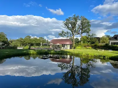 a reflection of a building in a lake at Hotel Flora Batava in Breukelen