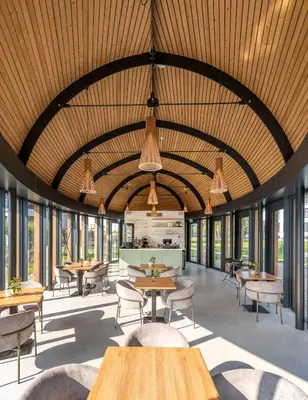 a dining room with tables and chairs and windows at Hotel Flora Batava in Breukelen