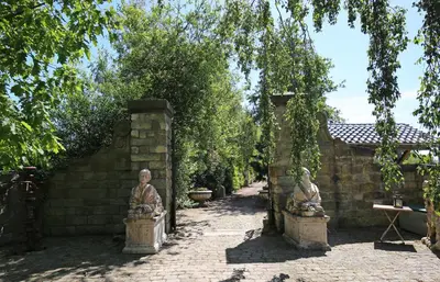 an archway with two statues in a garden at Boutique Villa De Zuilen in Hillegom