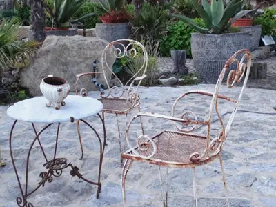 two iron chairs and a table with a vase on it at Boutique Villa De Zuilen in Hillegom
