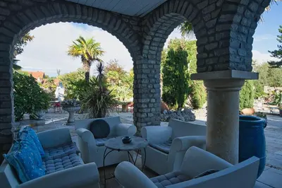 an outdoor patio with white chairs and a table at Boutique Villa De Zuilen in Hillegom