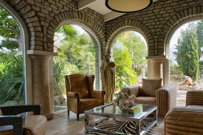an outdoor living room with arched windows and furniture at Boutique Villa De Zuilen in Hillegom