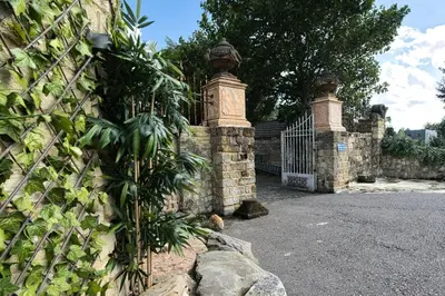 a stone fence with a gate and a tree at Boutique Villa De Zuilen in Hillegom