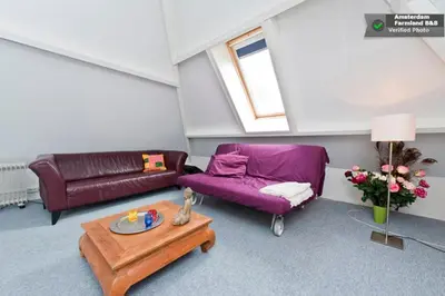 a living room with a purple couch and a table at Amsterdam Farmland in Amsterdam
