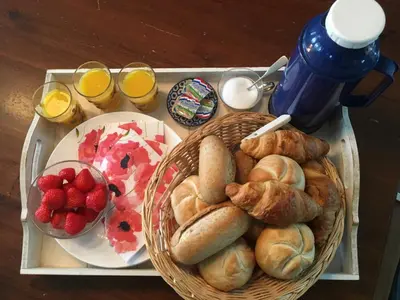 a tray with bread and croissants and fruit on it at Amsterdam Farmland in Amsterdam