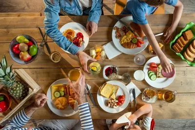 a group of people sitting around a table with food at Hotel Eemhof by Center Parcs in Zeewolde