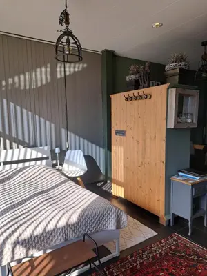 a bedroom with a bed and a wooden cabinet at Middelpunt Opmeer in Opmeer