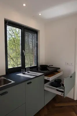 a kitchen with a black counter top and a window at Kwadijkerbos in Kwadijk