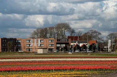 a field of tulips in front of a building at Hotel Lowietje Lisse - Keukenhof - Free Parking in Lisse