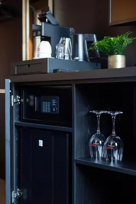 a microwave oven with two wine glasses on a shelf at Hotel Lowietje Lisse - Keukenhof - Free Parking in Lisse