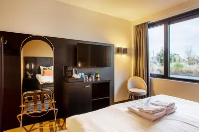 a hotel room with a bed and a tv at Hotel Lowietje Lisse - Keukenhof - Free Parking in Lisse