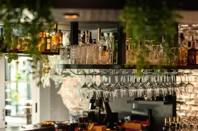 a bunch of glasses on a shelf in a bar at Hotel Lowietje Lisse - Keukenhof - Free Parking in Lisse