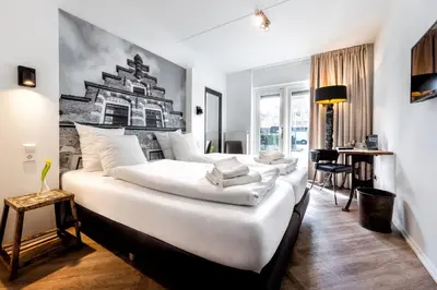 a hotel room with a large bed with white sheets at Broeck Oudewater in Oudewater
