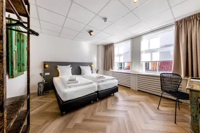 a hotel room with a bed and a chair at Broeck Oudewater in Oudewater