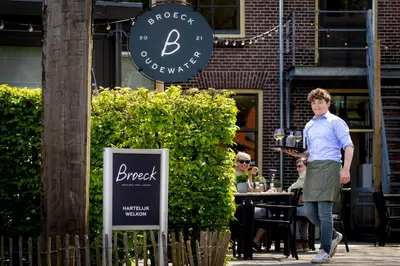 a man walking down a sidewalk in front of a restaurant at Broeck Oudewater in Oudewater