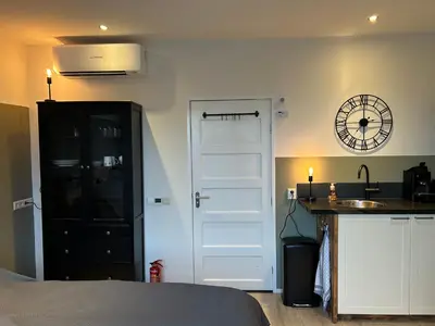 a bedroom with a door and a kitchen with a sink at Flowerbed in Voorhout