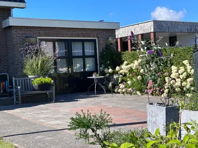 a patio with flowers in front of a building at Flowerbed in Voorhout
