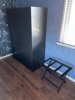 a blue room with a black cabinet and a table at Appartement Aqua in Oude Wetering