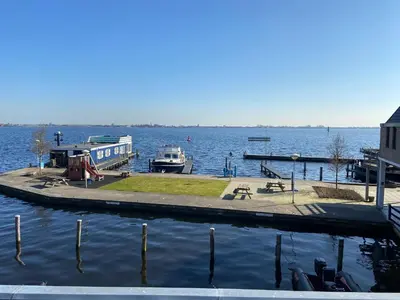 a dock with a boat in a large body of water at Appartement Aqua in Oude Wetering
