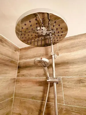 a shower head on a stand in a bathroom at Aris Amsterdam in Amsterdam