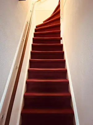 a staircase with red carpeting and a red stair case at Aris Amsterdam in Amsterdam