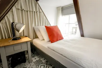 a bedroom with a bed and a desk and a window at Aris Amsterdam in Amsterdam