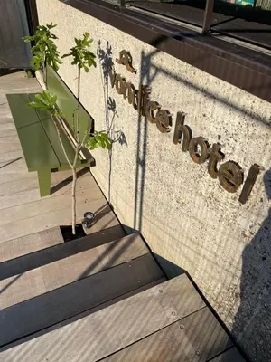 a sign on the side of a building with a plant at vondice hotel in Amsterdam