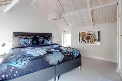 a bedroom with a bed with a blue comforter at Kusthuiskatwijk in Katwijk aan Zee