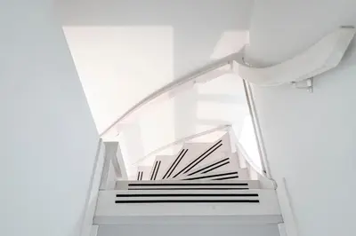 a staircase in a white room with white walls at Kusthuiskatwijk in Katwijk aan Zee