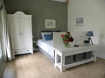 a bedroom with a bed and a table with flowers on it at Woubrugge Logies in Woubrugge