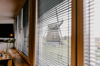 a window with a view of a windmill in a room at Millsight in Uitgeest