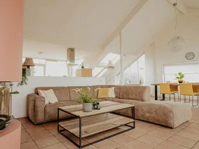 a living room with a couch and a table at Apartment Penthouse by Interhome in Uitgeest