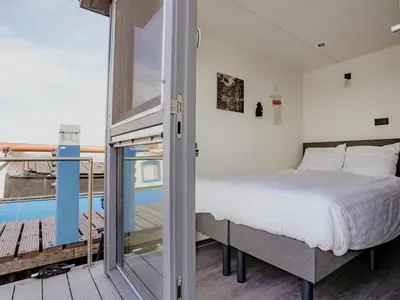 a bedroom with a bed and a balcony at Holiday Home De Meerparel-1 by Interhome in Uitgeest