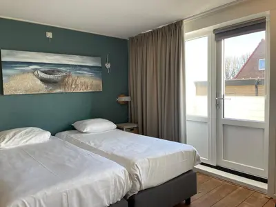a hotel room with two beds and a window at Fijne vakantiehuizen 50 mtr van het strand in Egmond aan Zee