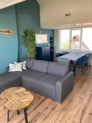 a living room with a couch and a table at Fijne vakantiehuizen 50 mtr van het strand in Egmond aan Zee