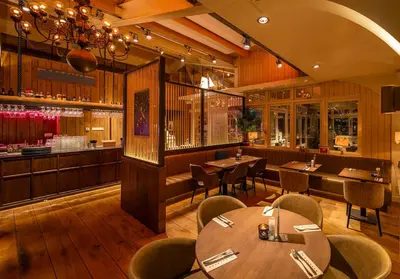 a restaurant with tables and chairs and a bar at Thalassa Beach Houses in Zandvoort
