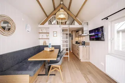 a kitchen with a long bench and a table at Thalassa Beach Houses in Zandvoort