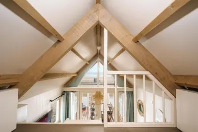 a large window in a room with wooden beams at Thalassa Beach Houses in Zandvoort
