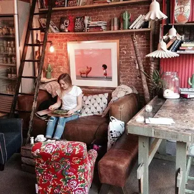 a woman sitting on a couch in a living room at HOMESTEAD Amsterdam in Amsterdam