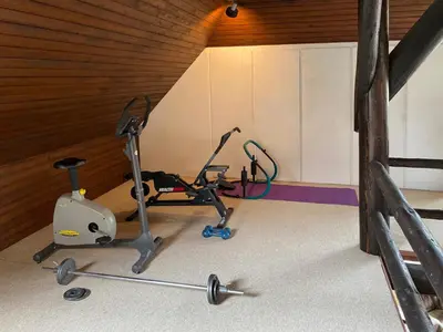 a gym with a treadmill and a exercise bike at Koningshof in Schoorl