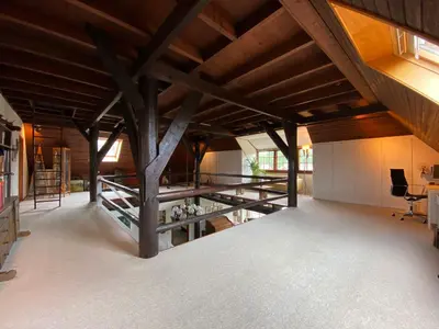 a large room with wooden ceilings and beams at Koningshof in Schoorl