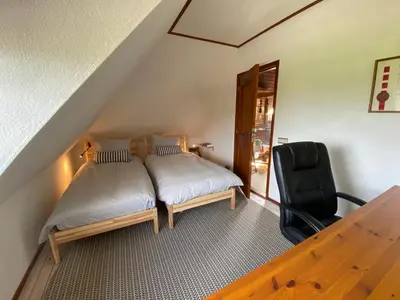 a bedroom with a bed and a black chair at Koningshof in Schoorl