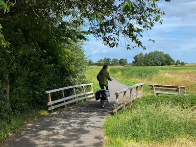 a man walking a bike down a path at Koningshof in Schoorl