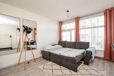 a living room with a couch and a large window at Amsterdam Beach Apartment 44 in Zandvoort