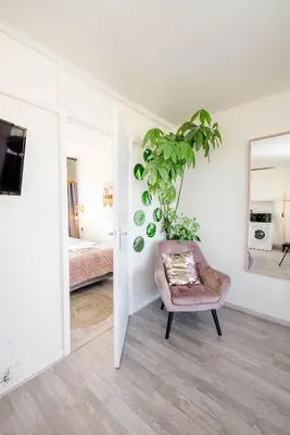 a white room with a chair and a plant at Amsterdam Beach Apartment 44 in Zandvoort