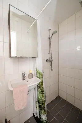 a white bathroom with a sink and a mirror at Amsterdam Beach Apartment 44 in Zandvoort