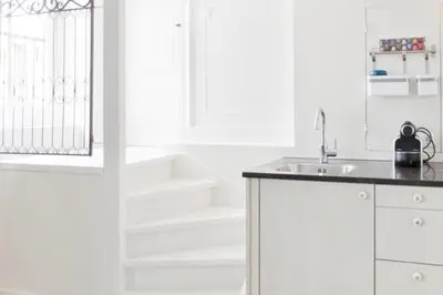 a white kitchen with a sink and stairs at Luna's Hideaway in Amsterdam