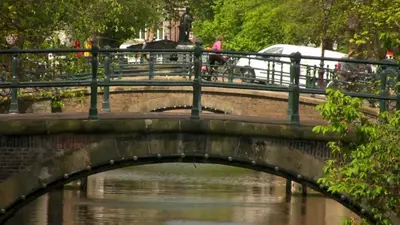 a bridge over a river with people walking on it at Luna's Hideaway in Amsterdam