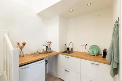 a kitchen with white cabinets and a wooden counter top at Boutique Studio Magielsen in Amsterdam